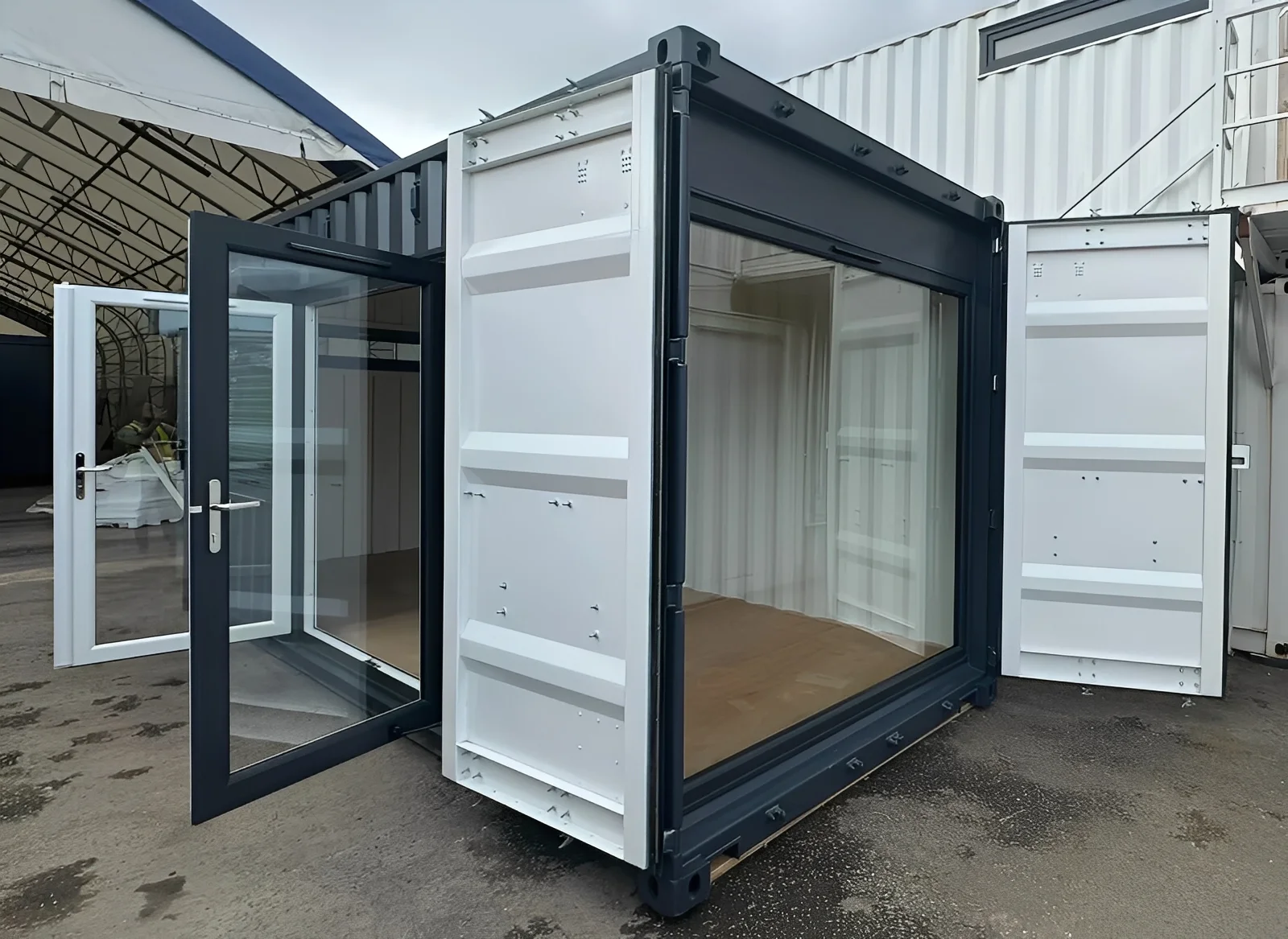 20ft x 8ft Custom Shipping Container Conversion – Portable Building Key Features (As Shown in This 20ft Model) Base Container Options: 20ft x 8ft High Cube Container (9′6″ high) or 20ft x 8ft Standard Container (8′6″ high) Exterior Finish: Full external respray in Anthracite Grey Internal respray in White for a bright interior Chrome container handles for a polished look Entry & Access: Manual Roller Shutter Door (2000 × 1000 mm), steel shopfront style, powder-coated finish with bullet locks for security Double-Glazed Anthracite Grey French Doors (2000 × 2200 mm) – stylish and secure